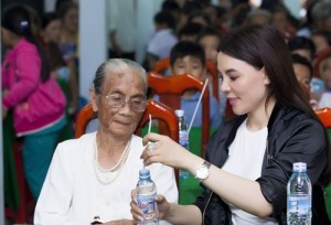 Mai Phương Trang giúp cụ bà mở chai nước