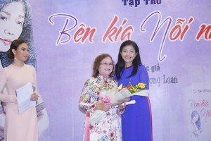 Tác giả Trần Lê Phượng Loan tặng hoa và ôm cô giáo cũ kính yêu của mình