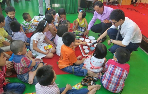 Nghệ sĩ Mai Đình Tới và MC Pobla hướng dẫn các em cách chơi đàn chén