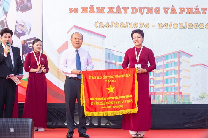 Ông Trần Văn Bảy - Phó Chủ tịch UBND TP.HCM trao tặng cờ truyền thống cho cô Nguyễn Thị Thanh Huệ - Hiệu trưởng Trường PTĐB Nguyễn Đình Chiểu tại lễ kỷ niệm