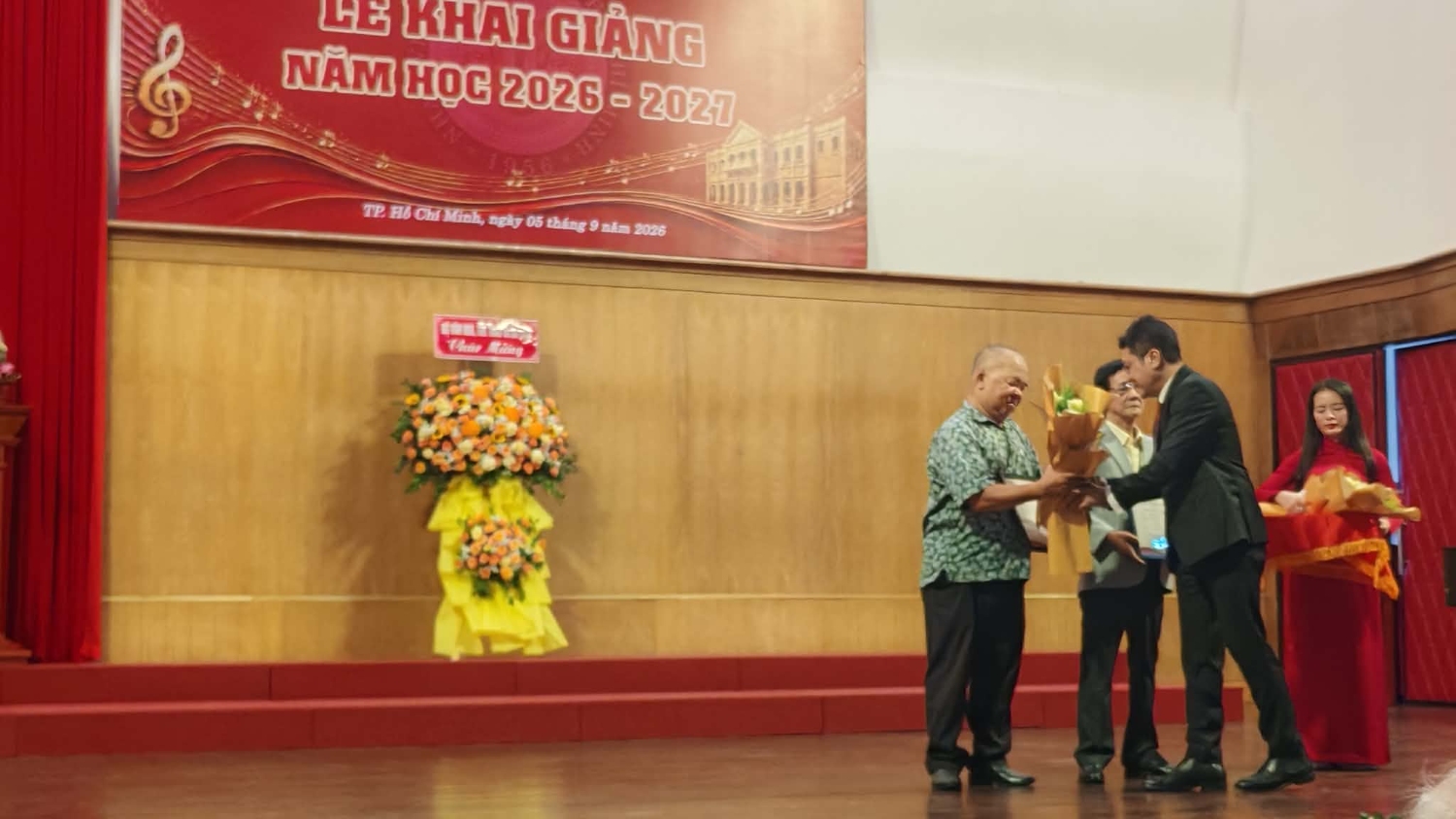 Tiến sĩ - NSND Đỗ Quốc Hưng (Giám đốc Nhạc viện TP.HCM) tặng hoa và bằng chứng nhận giải thưởng cho nhạc sĩ Huỳnh Minh Trí